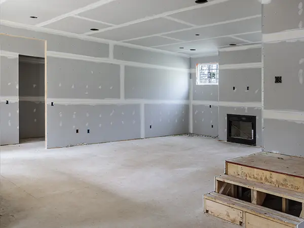 A basement remodel project with an empty space and a fireplace in wall