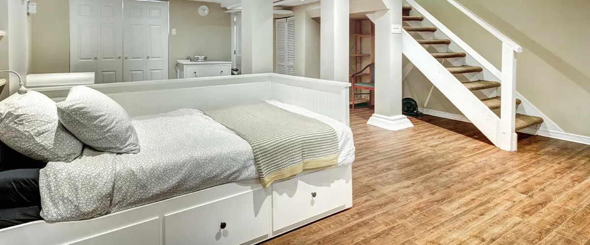 A basement transformed into a bedroom with wood flooring