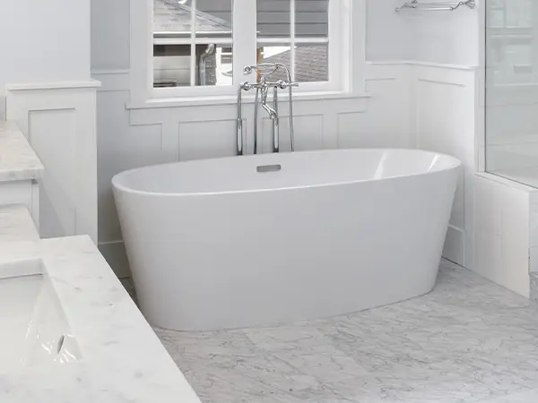 A freestanding tub in a bath with large tile floors