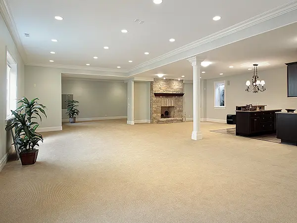 An empty basement with carpet flooring