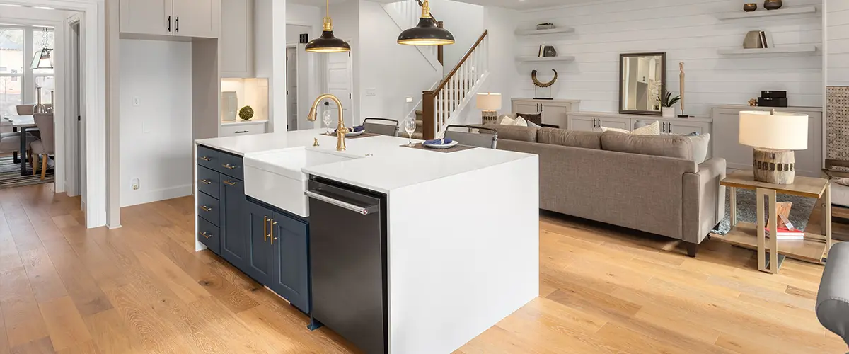 Wood flooring with kitchen island, blue base cabinets, in an open space room