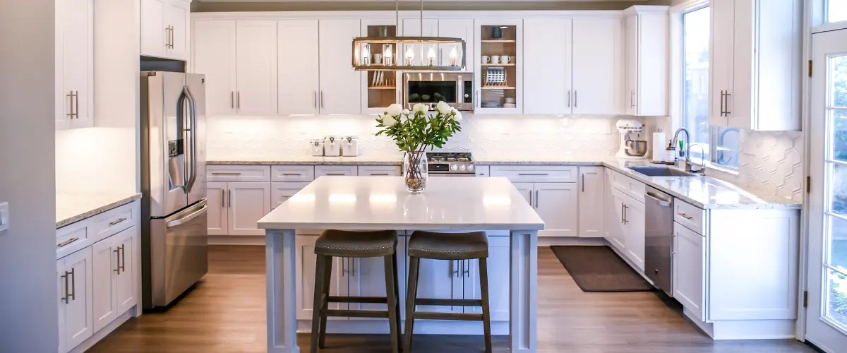 A kitchen with white cabinets and an island
