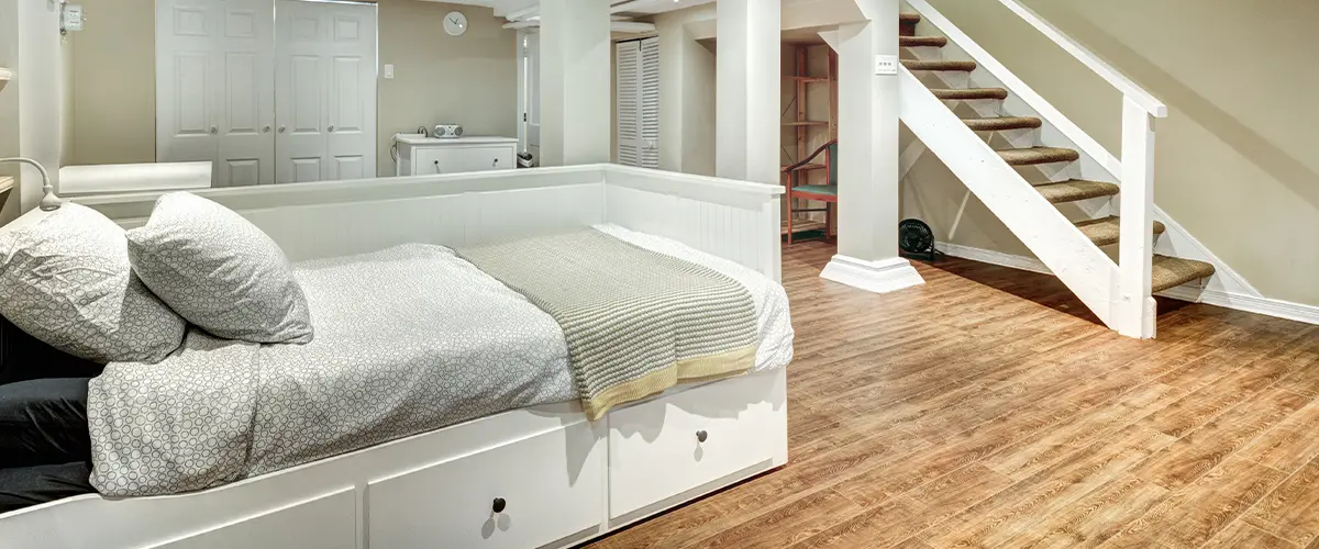 A bedroom in a basement with wood flooring