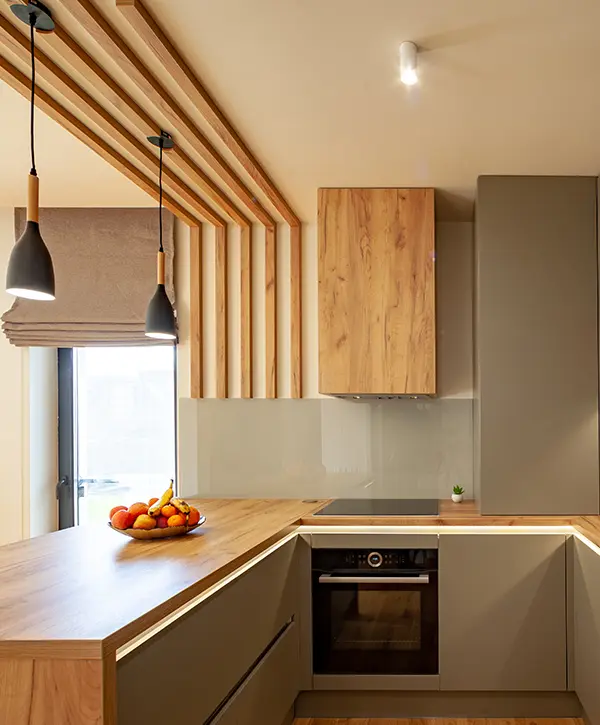 A modern kitchen with wood features and overhang lighting