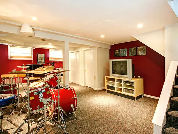 A room with carpet floor and a set of drums