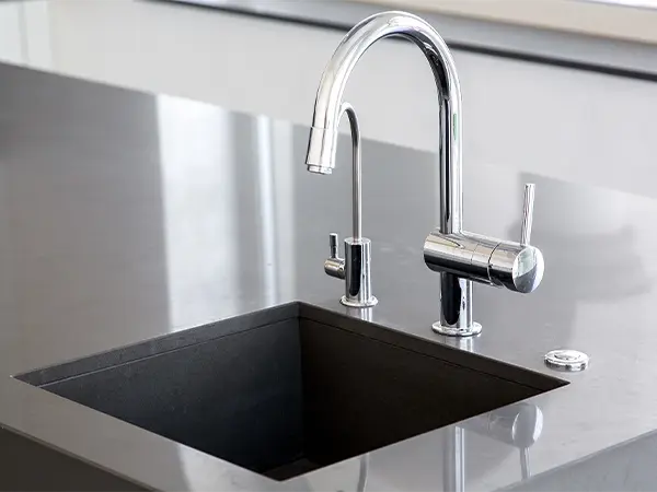 Modern, undermount sink with a silver faucet and shiny countertop