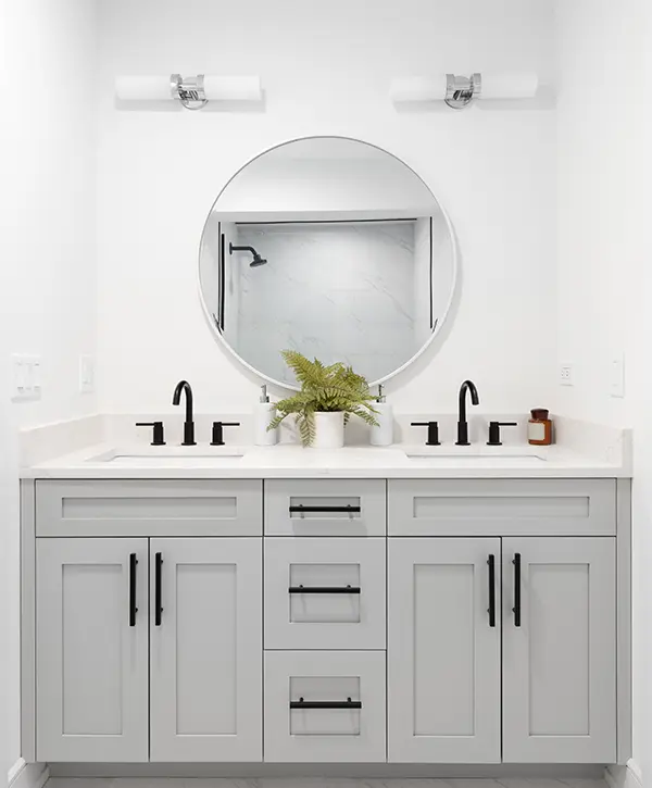 A beautiful light gray vanity with black hardware