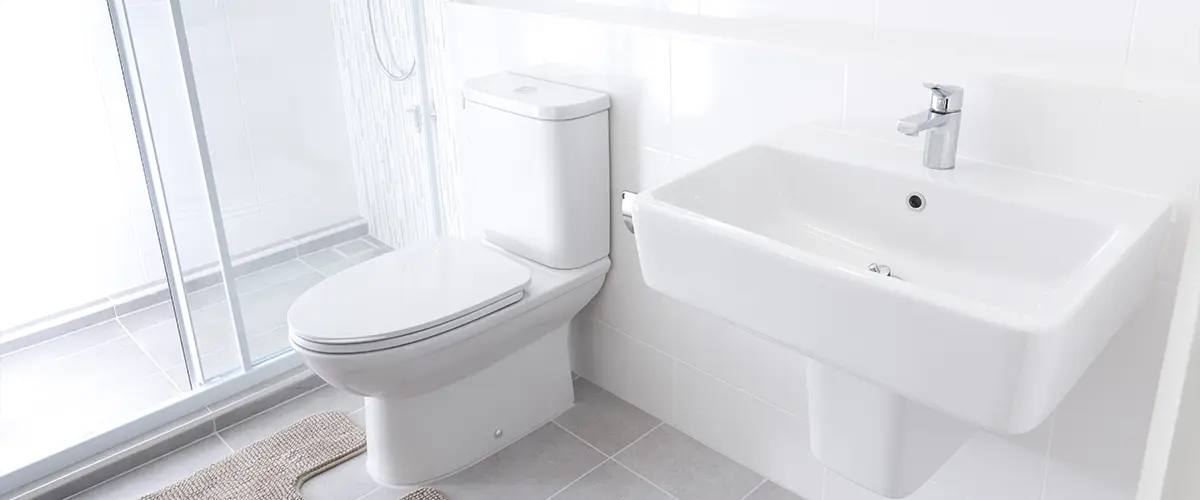 A white toilet and a pedestal sink