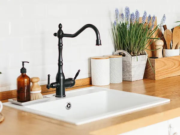 A drop-in sink with a black faucet
