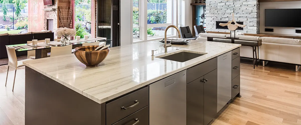 A quartz countertop on a kitchen island in a space with wood flooring