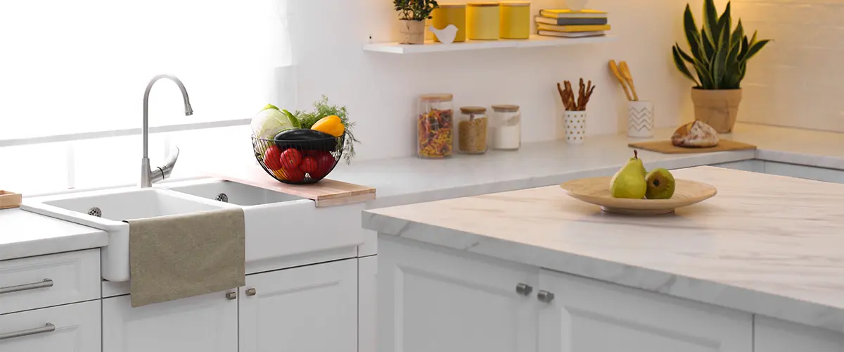 A quartz countertop with plants and a bowl of fruits