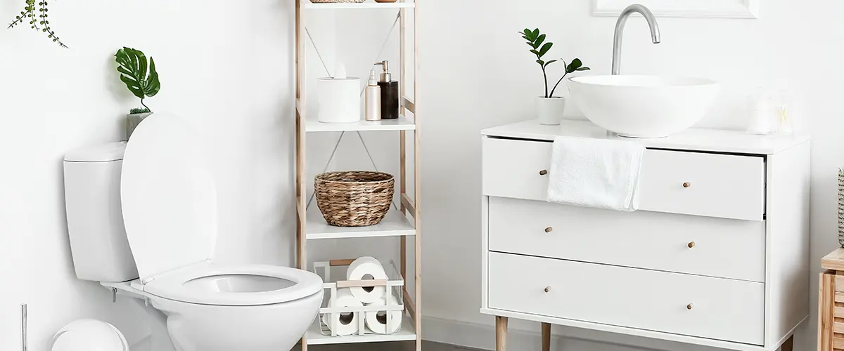 A toilet and a white vanity with a vessel sink