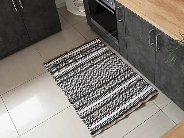 A tile flooring with a small carpet