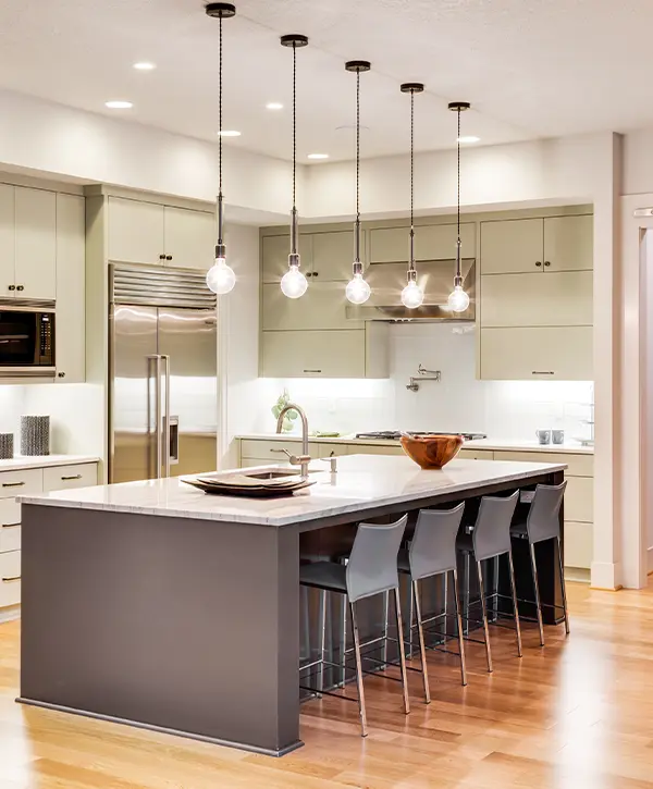 Beige cabinets with overhang lighting above a large island