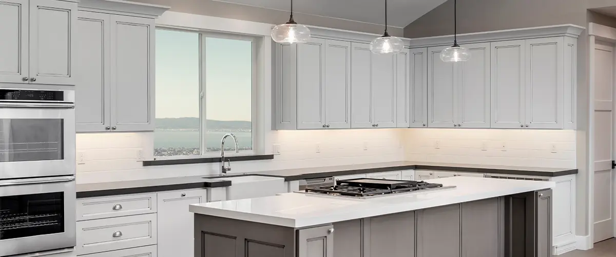 Light gray kitchen cabinets with overhand lights