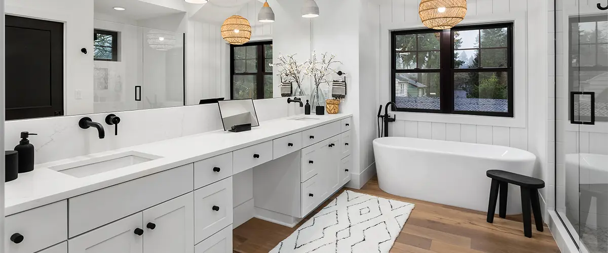 Bathroom with a large vanity with dark hardware and LVP floors