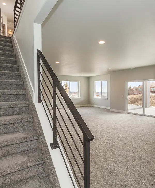 Carpet flooring in a basement with a set of stairs