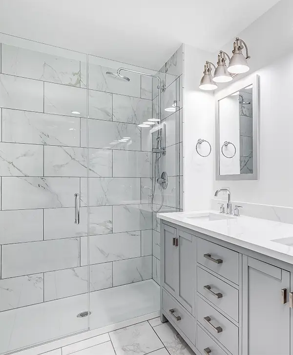 Gray vanity with a glass tiled shower