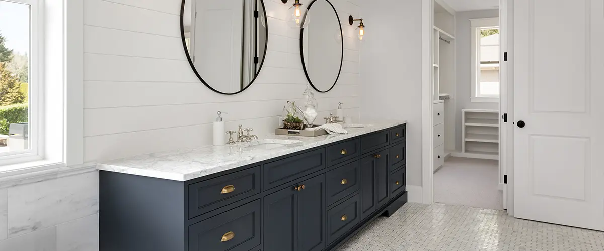 Dark blue double vanity with round mirrors and tile floor