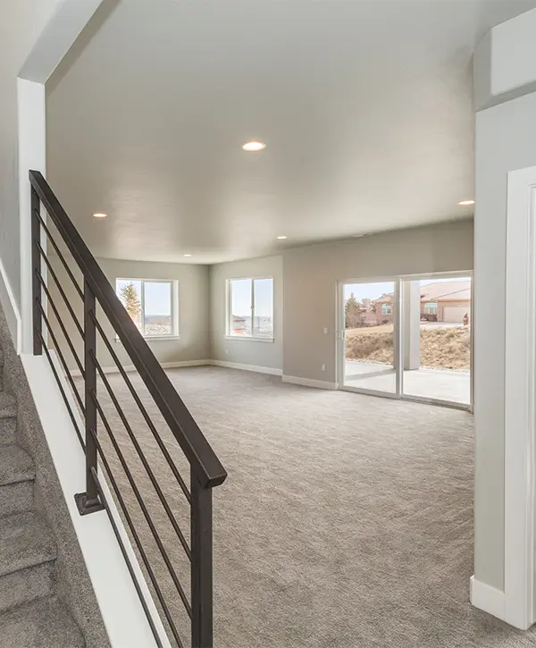 A basement finishing project in Papillion with carpet flooring and large french doors