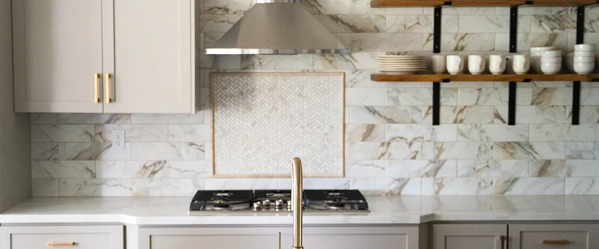 Tile backsplash with golden faucet and quartz top