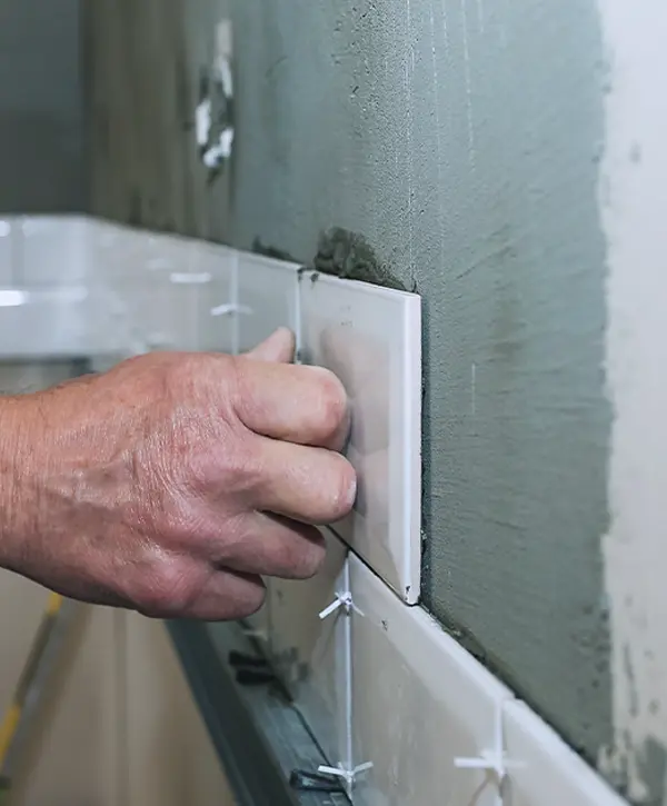 Man in Paillion Tiling A Bathroom Wall