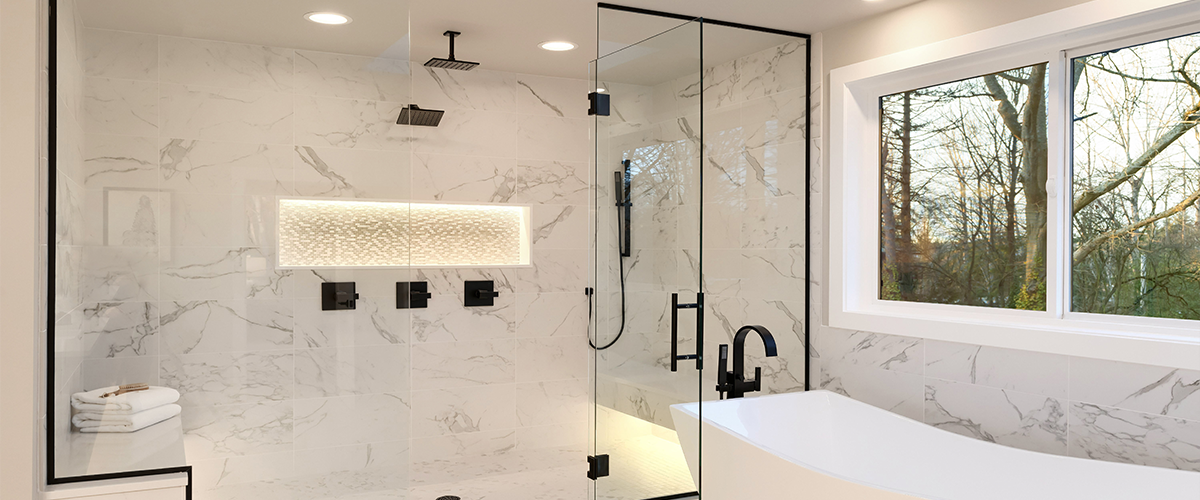 Contemporary bathroom featuring a spacious glass shower enclosure with marble walls, black fixtures, a built-in lighted niche