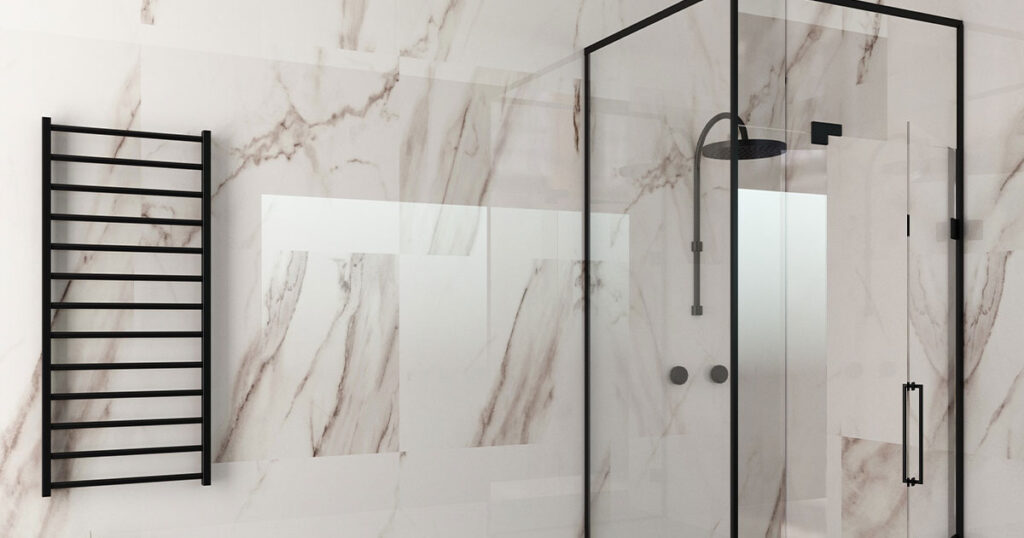 Modern bathroom with marble shower walls, glass shower enclosure, black fixtures, towel rack, and decorative plants on grey tiled floor.