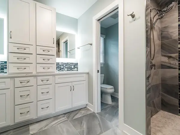 Contemporary bathroom with custom white cabinetry, tiled shower, and sophisticated design elements for a luxurious home retreat.