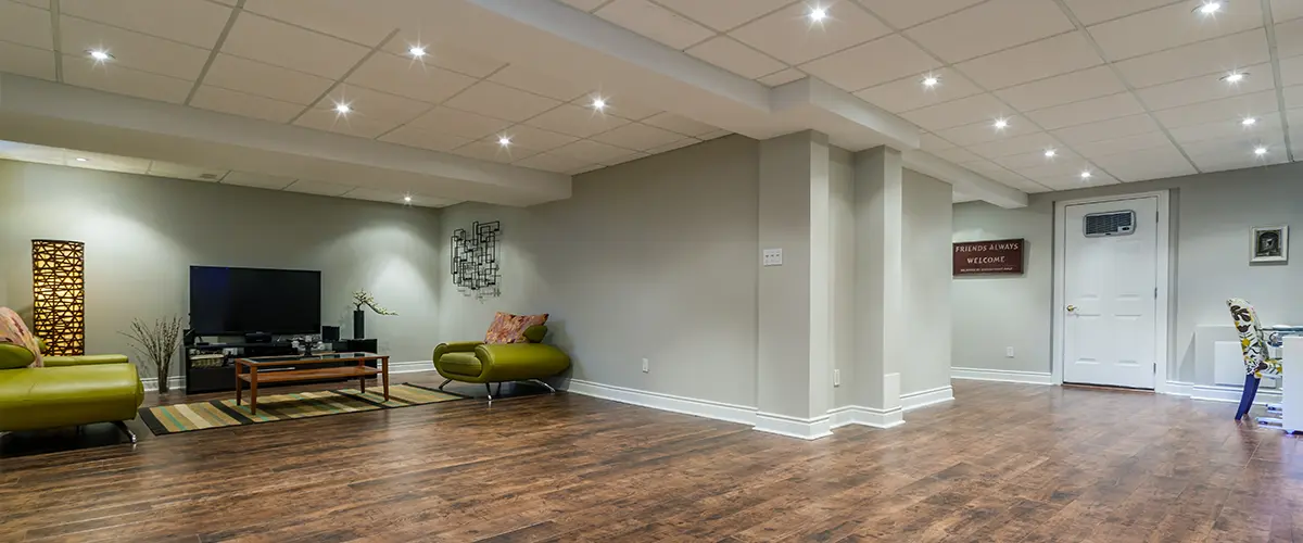 Open finished basement with hardwood floors, recessed lighting, and a home entertainment setup.