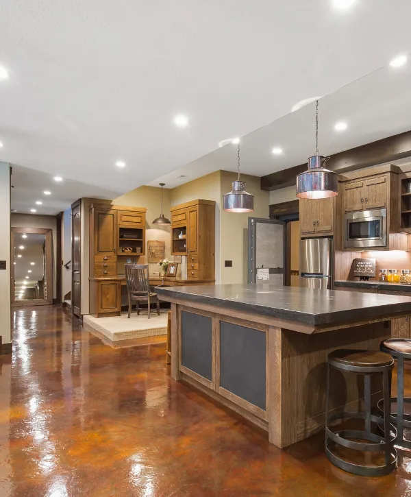 Rustic basement design with polished concrete floors, a wooden kitchen island, and cozy lighting.