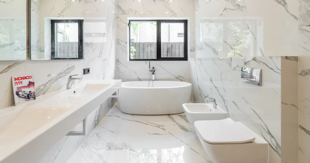 Luxurious marble bathroom with a freestanding tub, double sink, and bidet.