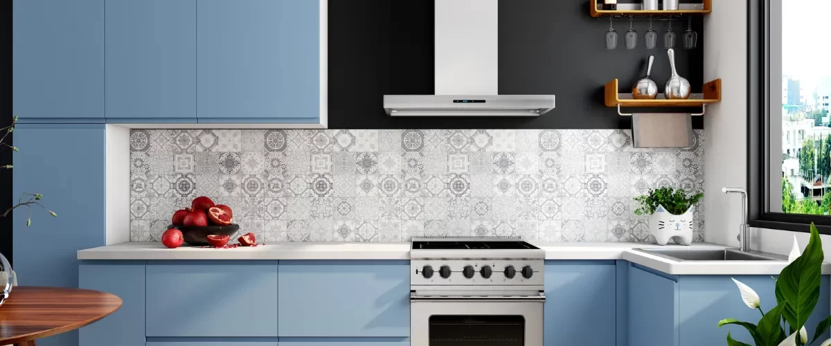 Modern kitchen with blue cabinets, a patterned backsplash, and a sleek stovetop design.