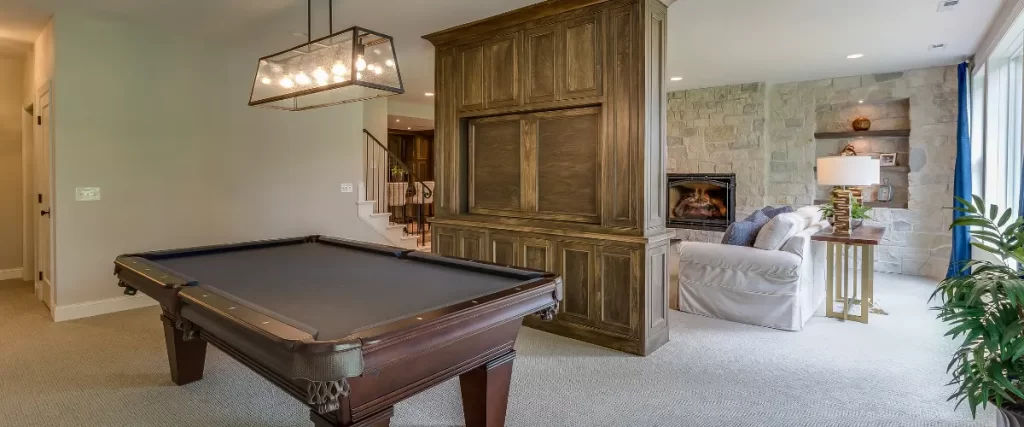 Luxury basement with pool table, wood paneling, and fireplace lounge