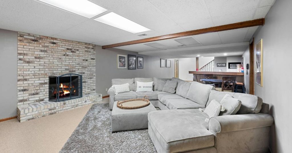 Cozy basement family room with sectional sofa and brick fireplace