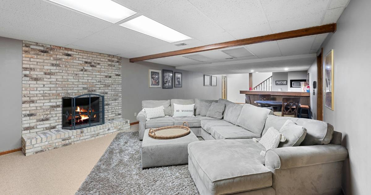 Cozy basement family room with sectional sofa and brick fireplace