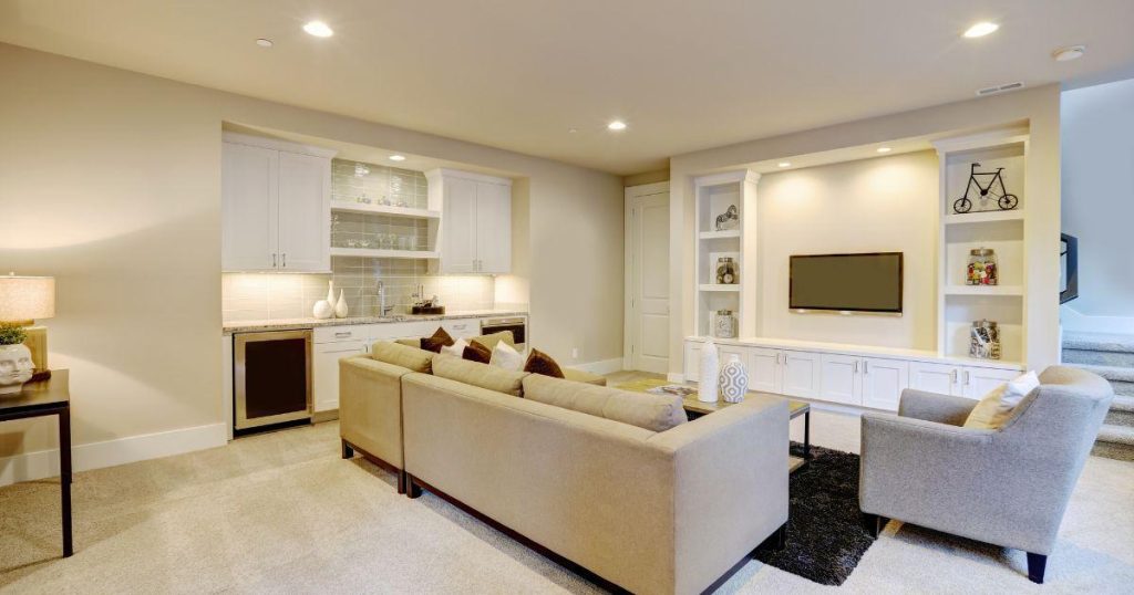 Alternate angle of cozy basement living area with entertainment center and bar nook