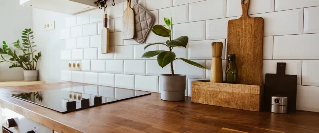 Wood countertop kitchen with white subway tile backsplash and indoor plant